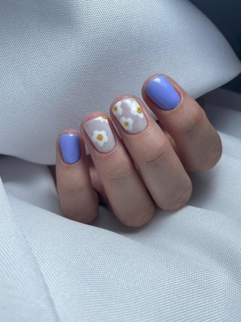 Uñas lila con flores blancas pintadas a mano